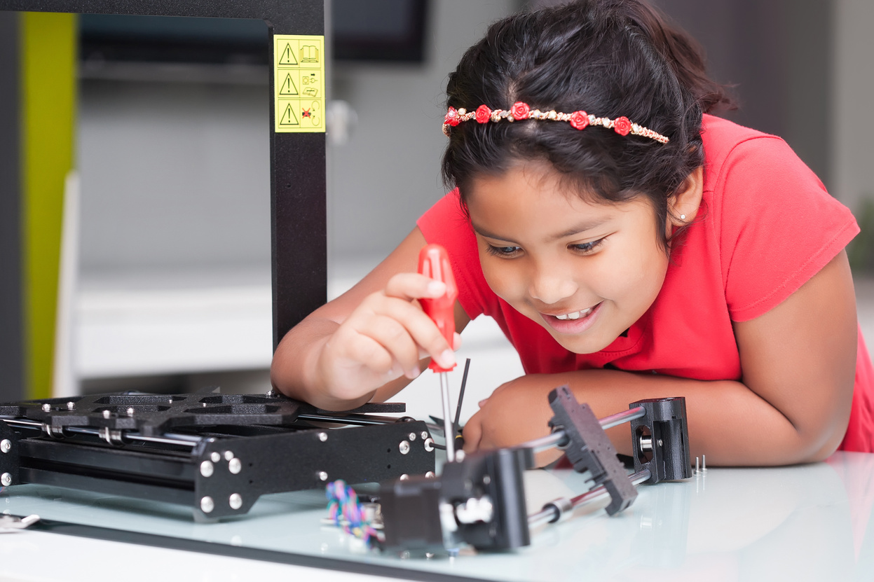 Genius level kid learning about 3D printers by building it and following directions in STEM class