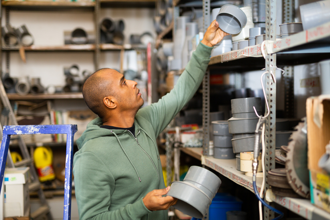 Hispanic man looking for construction supplies in building hypermarket